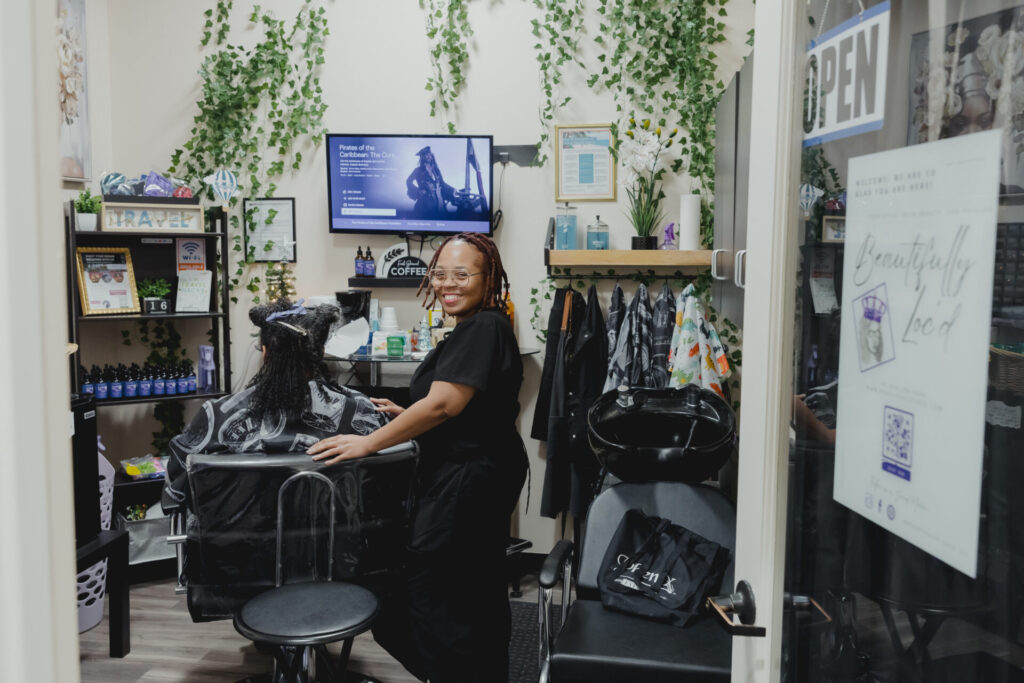 Hair stylist smiling in salon with client