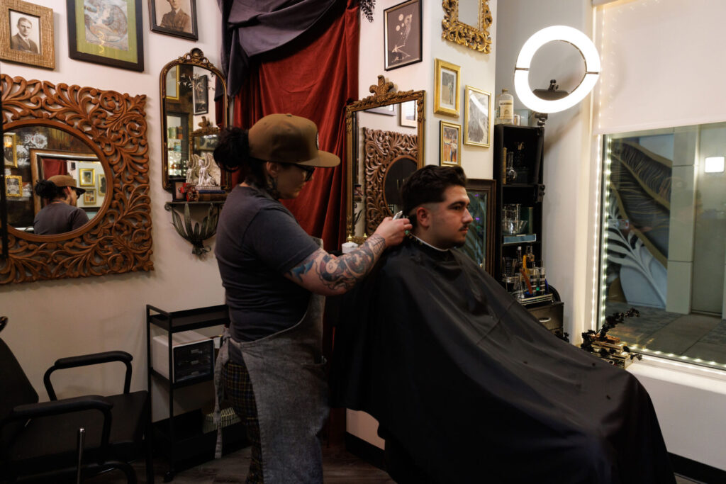 Barber giving haircut in stylish salon.