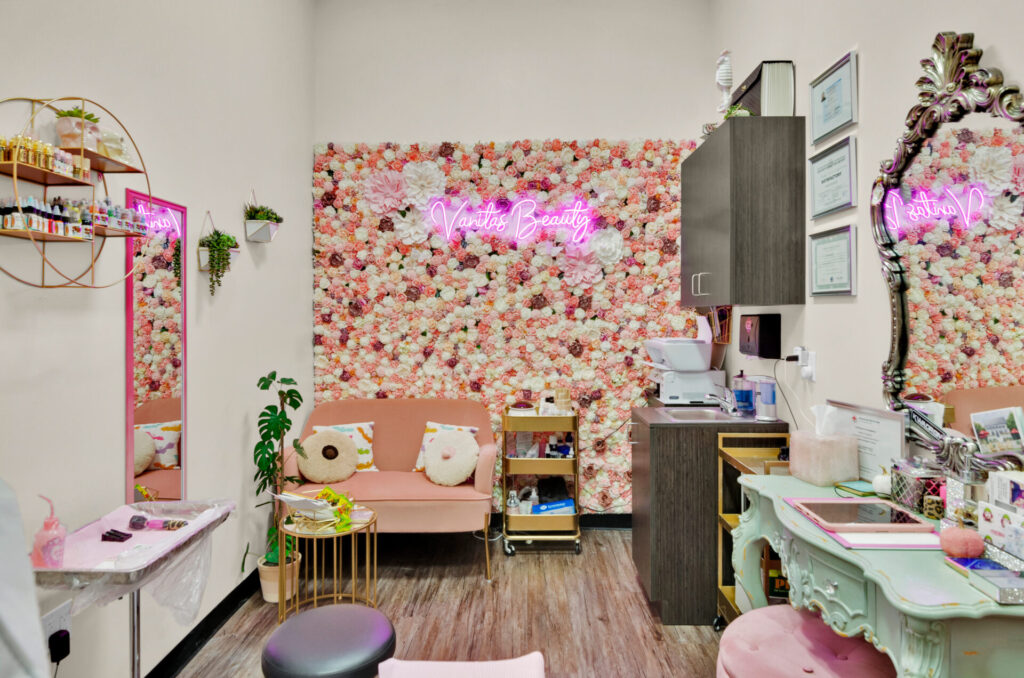 Beauty salon interior with floral wall and pink decor.