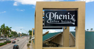Phenix Salon Suites sign by palm-lined road